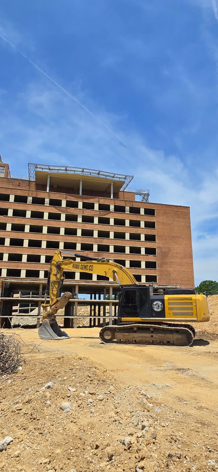 Robo Demo Co. excavator demolishing a multi-story concrete structure